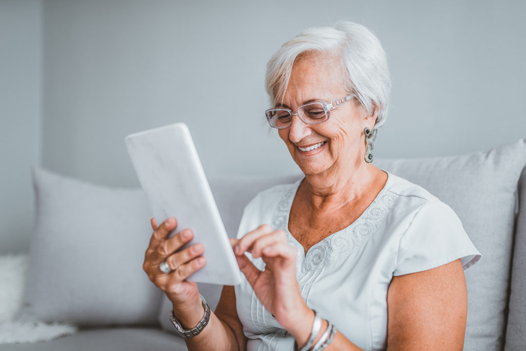 Senhora se divertindo com um tablet nas mãos